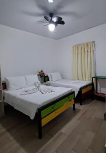 um quarto com 2 camas e uma ventoinha de tecto em Hotel La Castella em San José