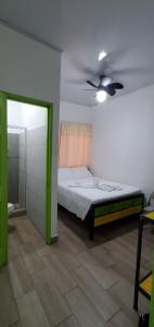 um quarto com uma cama e uma ventoinha de tecto em Hotel La Castella em San José