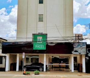 samochód stoi przed budynkiem w obiekcie Hotel Fatti w mieście Maringá