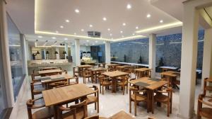 an empty restaurant with wooden tables and chairs at Hotel Fatti in Maringá