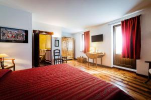 ein Hotelzimmer mit einem roten Bett und einem Fenster in der Unterkunft B&B Al Nabuisson in Aosta + 4 Fotos