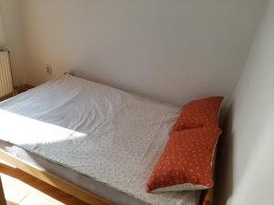 - un petit lit avec un oreiller rouge dans l'établissement IV2020 apartment, à Skopje