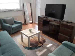 a living room with a tv and a couch and a table at IV2020 apartment in Skopje
