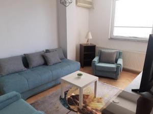 - un salon avec un canapé bleu et une table dans l'établissement IV2020 apartment, à Skopje