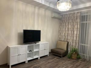 a living room with a television and a chair at 2-комнатная квартира на Соборной in Mykolaiv