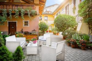 eine Außenterrasse mit weißen Stühlen und Pflanzen in der Unterkunft B&B Al Nabuisson in Aosta