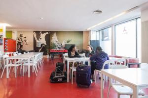 two women sitting at tables with their luggage in a restaurant at Abigail's Hostel in Dublin +39 photos