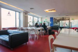 um restaurante com mesas e cadeiras e pessoas sentadas a mesas em Abigail's Hostel em Dublin