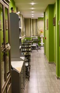 einen Friseursalon mit grünen Wänden, Tischen und Stühlen in der Unterkunft Hotel De La Ville Relais in Fiumicino