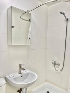 Baño blanco con lavabo y espejo en Apartments Osokorky House, en Kiev