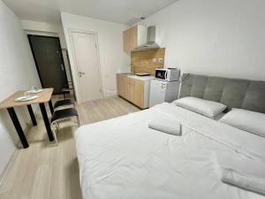 1 dormitorio con cama, mesa y cocina en Apartments Osokorky House, en Kiev