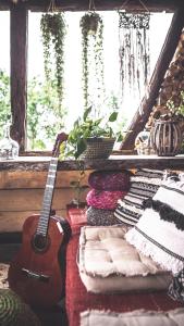 a guitar sitting in a room next to a window at Nooks by AdyBeca - Balnaca Traditional Nook in Bălnaca