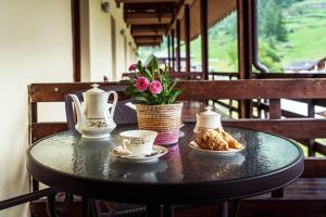 un tavolo nero con tazze da tè e fiori sopra di Chalet du Lys Hotel & SPA a Gressoney-la-Trinité