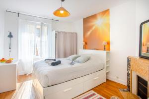 um quarto com uma grande cama branca em frente a uma lareira em L'Aparté HYPER CENTRE LUMINEUX em Lorient