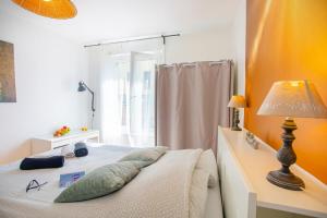 a bedroom with a bed with a lamp and a window at L'Aparté HYPER CENTRE LUMINEUX in Lorient