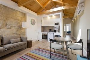 a kitchen and living room with a table and chairs at RVA - Clerigos Apartments in Porto