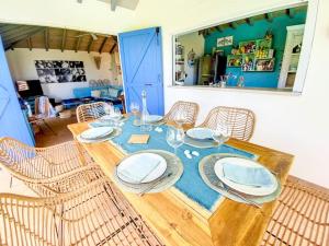a dining room table with chairs and a blue table at Aquamarine, private room in Villa Casa Blue pool sea view in Koolbaai