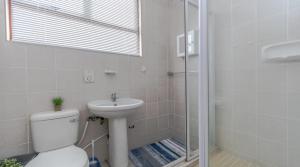 a bathroom with a toilet and a sink and a shower at Sunrise Pool At 201 in Ballito