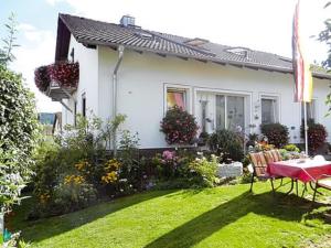 a white house with a table and chairs in a yard at Ferienwohnungen Meyer in Beilngries