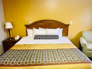 New Buffalo的住宿－鄧坎紅地毯酒店，一间卧室配有一张床、一张沙发和一把椅子