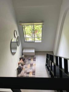 a woman sitting on a couch in a room with a window at 304A-APARTA ESTUDIO DUPLEX MINI EN Granada in Cali