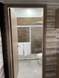 a bathroom with a toilet and a glass door at 304A-APARTA ESTUDIO DUPLEX MINI EN Granada in Cali
