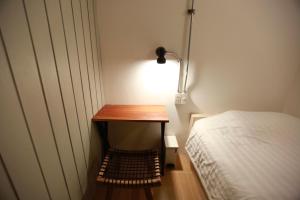 a small table with a lamp next to a bed at My Home Hostel in Ban Na Kham