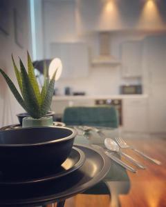 a table with a plant in a bowl on it at The Law House By The Opulence - Free City Centre Parking in Bradford