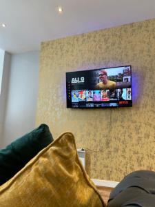 a tv hanging on a wall in a living room at The Law House By The Opulence - Free City Centre Parking in Bradford