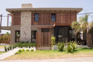 a house with wooden facade with a palm tree at Casa Tilo in José Ignacio