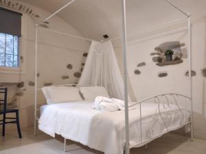 ein weißes Schlafzimmer mit einem weißen Himmelbett in der Unterkunft Casa Roberta in Dolceacqua