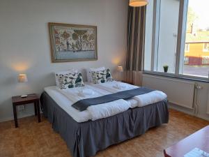 Cette chambre comprend un grand lit et une grande fenêtre. dans l'établissement Kristinebergs Bed & Breakfast, à Mora