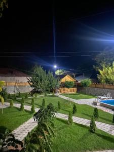 un jardín con piscina por la noche en Green Garden Garni, en Garni