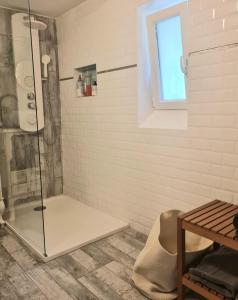 La salle de bains est pourvue d'une douche avec une porte en verre. dans l'établissement Appartement, atelier d'artiste, à Chelles