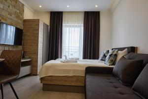 a hotel room with a bed and a couch at L&N Apartmani Kopaonik-Milmari Resort in Kopaonik