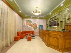 uma sala de estar com um sofá e uma televisão na parede em KangAr guest house em Yerevan