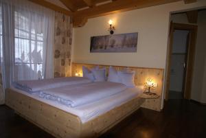 a bedroom with a large bed with white sheets and pillows at Sonnenschlössl Apartments in Neustift im Stubaital