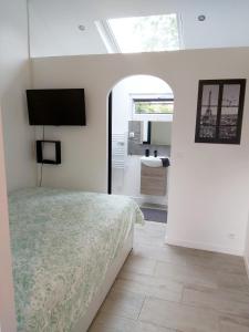 1 dormitorio con 1 cama y TV en Superbe studio 15 m²,proche Disney, Asterix, CDG en Gressy