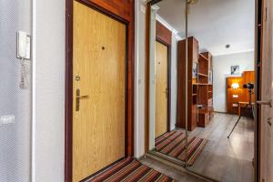 pasillo con puerta de madera y espejo en Business Brusnika Apartments Arbatskaya, en Moscú