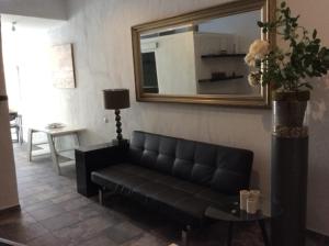 a black couch in a living room with a mirror at Urlaub im kleinen Bergparadies in Las Casillas