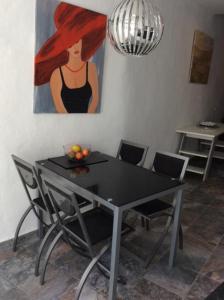 a dining room table with chairs and a painting of a woman at Urlaub im kleinen Bergparadies in Las Casillas