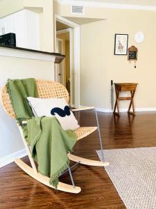 een schommelstoel met een groene deken in de woonkamer bij Peaceful Medical Center Apartment 2BR & 2BA in Houston