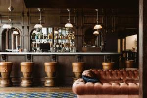 a bar with a brown leather couch in a room at Rusacks St Andrews in St. Andrews