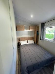 a small bedroom with a bed in a tiny house at Mobilhome Salsa XXL in Gastes