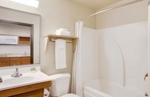 
a bathroom with a sink, toilet and bathtub at WoodSpring Suites Washington DC Andrews AFB in Camp Springs
