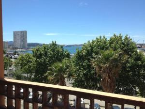 a view of the ocean from a balcony with palm trees at Portman cosy in Toulon