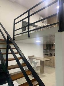 a staircase in a room with a table and a loft at 304-BELLISIMO Apartaestudio DUPLEX EN GRANADA in Cali