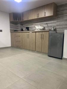 a kitchen with wooden cabinets and a black refrigerator at 304-BELLISIMO Apartaestudio DUPLEX EN GRANADA in Cali