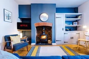 ein Wohnzimmer mit einem Kamin und einer blauen Wand in der Unterkunft Fisherman's Cottage in Chester