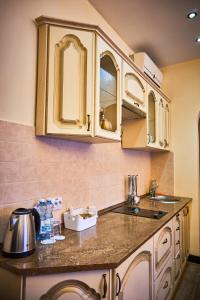 a kitchen with white cabinets and a counter top at Двокімнатні апартаменти на Лукіяновича, 3 in Lviv